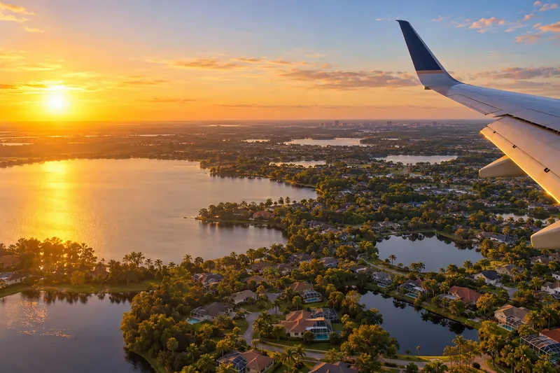Illustration: View from an airplane window over Central Florida lakes at golden hour